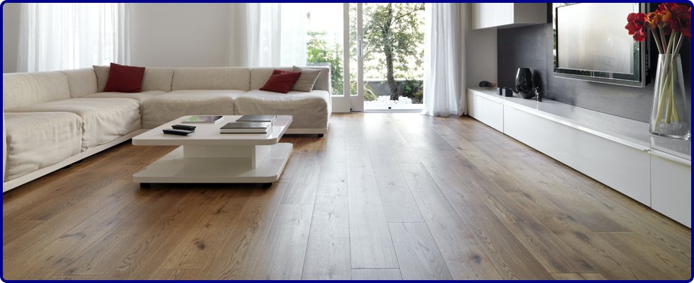 Real wood flooring in a living with a large, cream corner sofa and white coffee table